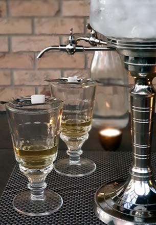 Absinthe Fountain, Glasses with Absinthe, Slotted Spoons and Sugar